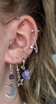 a close up of a person with ear piercings on their ears and wearing jewelry