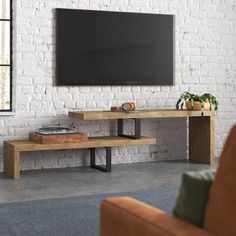 a living room with white brick walls and a television on the wall in front of it