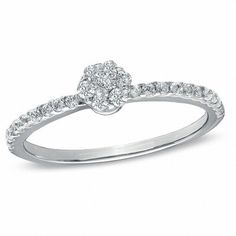 a white gold ring with diamonds on the band and an oval shaped diamond in the center