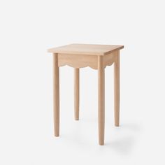 a small wooden table sitting on top of a white floor