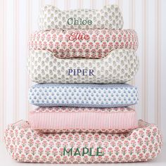 four pillows stacked on top of each other in front of a wallpapered background