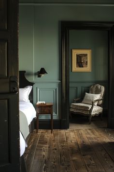 a bedroom with green walls and wooden floors