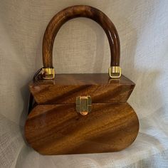 a wooden purse sitting on top of a white sheet