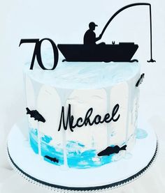 a white cake with blue frosting and a man in a boat on top that reads 70