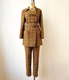 Vintage 1970s mustard and brown double-breasted pantsuit with rounded oversized collar, patch pockets.  The pants have a perfect taper to compliment the statement jacket. Excellent vintage condition with now flaws to note. Label: Pendleton Jacket Measurements: Shoulders: 17" Bust: 40" Waist: 39" Hips: 44" Length: 31" Trouser Measurements: Waist: 31" Hips: 41" Length: 40" Retro Notch Lapel Fall Suits, Retro Notch Lapel Suits For Fall, Fall Retro Suits With Notch Lapel, Retro Fall Suits For Tailoring, Retro Tailored Suit For Fall, Brown Fall Pantsuit For Office, Vintage Double-breasted Suits For Workwear, Tailored Retro Suits For Workwear, Tailored Brown Pantsuit For Fall