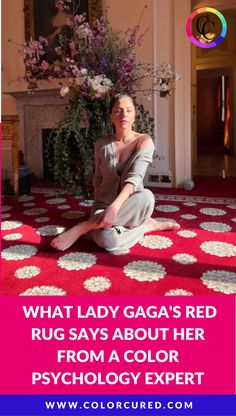 a woman sitting on the floor in front of a red rug