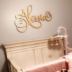 a baby crib in a room with a name sign above it