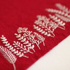 a red and white table cloth with embroidered designs on it