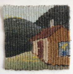 an embroidered piece of fabric with a house on it