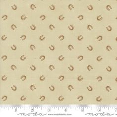 an image of a beige fabric with brown and white designs on it, as well as a ruler