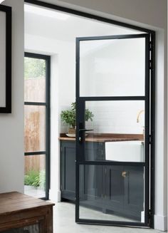 an open glass door leading to a kitchen