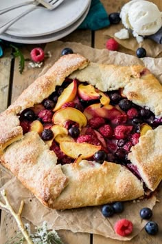 a pie topped with fresh fruit on top of a wooden table