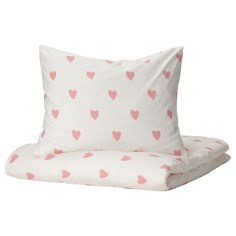 two pillows on top of each other with pink hearts printed on the pillowcases