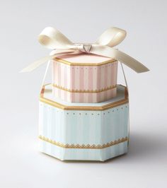 three stacked boxes with ribbons tied around the top one is pink, blue and white