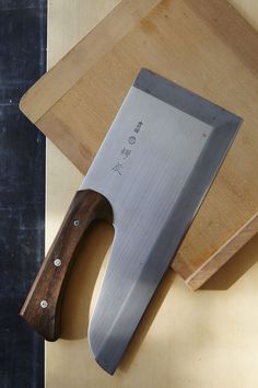 a large knife sitting on top of a cutting board