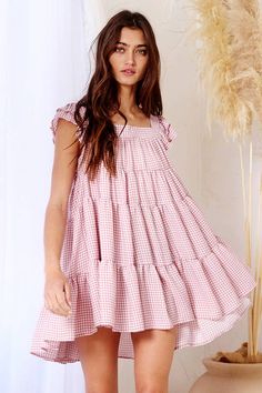 Our Penelope Gingham Print Tiered Babydoll Mini Dress is perfect for those hot summer days. It has a square neck and back, is pleated to give a flattering shape and features a tiered silhouette making it flowy while not looking misshapen! Summer Sundress With Ruffled Straps For Picnic, Casual Gingham Tiered Dress, Casual Tiered Gingham Dresses, Cute Tiered Ruffle Sundress, Square Neck Dress With Smocked Back For Picnic, Cute Tiered Ruffled Sundress, Mini Sundress With Ruffles For Picnic, Gingham Dress With Ruffled Straps For Summer, Cute Tiered Dress For Garden Party