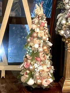 a decorated christmas tree next to a window