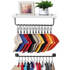 a rack with hats and pants hanging from it's hooks, next to a potted plant