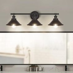 a bathroom vanity with three lights above it