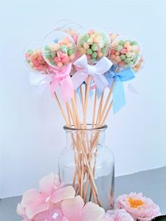 a vase filled with candy and flowers on top of a table