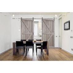 a dining room table and chairs with sliding doors on the wall in front of it