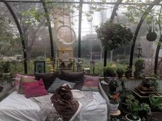 a bed in a room with lots of potted plants