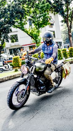 a man riding on the back of a motorcycle down a street