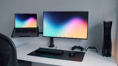 two computer monitors sitting on top of a white desk