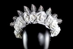 Introducing one of our reversible crowns--a work of art that embodies the delicate balance between modern innovation and timeless beauty. This exceptional crown showcases a stunning harmony of elements. It features gentle white zip ties, pristine white roses, radiant silver roses, and intricate metal silver leaves, making it a reversible masterpiece that offers two distinct yet equally captivating looks. One side of the crown is adorned with delicate white roses that exude a gentle elegance, sym Luxury Wedding Headpieces, White Crown Headpieces As Gift, High Crown Headpieces For Wedding, Wedding Jewelry With High Crown And Crown Design, Luxury Formal Headpiece With Structured Crown, Adjustable High Crown Headpiece For Wedding, Luxury Adjustable Wedding Headpieces, Luxury Adjustable Headpieces For Weddings, Luxury Adjustable Headpieces For Formal Occasions