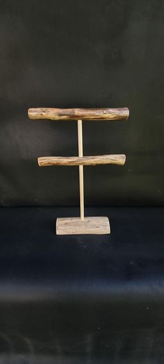 a wooden stand with two pieces of wood sticking out of it's sides on a black surface