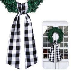 a black and white checkered ribbon with a green wreath on it next to an open window