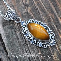 Handmade, Natural Tigers Eye Sterling Silver pendant on a 18" Sterling Silver Chain. ❤︎Featured in this listing is a sterling silver, handmade, natural stone pendant.  This lovely handmade pendant features a beautiful, Natural Tiger's Eye marquise shaped stone.  ❤︎The lovely marquise stone has been bezel set into a highly polished, victorian style embellished Sterling Silver setting, with with a large detailed bail.   ❤︎All made with Sterling Silver and comes featured on an 18" Chain  Main Stone Sterling Silver Brown Necklace For Gift, Brown Hallmarked Sterling Silver Jewelry, Elegant Brown Sterling Silver Necklace, Brown Hallmarked Jewelry As Gift, Hallmarked Brown Jewelry As Gift, Brown Hallmarked Jewelry Gift, Brown Polished Jewelry As Gift, Polished Brown Jewelry Gift, Brown Polished Finish Jewelry Gift