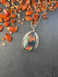 "This stone is a man made aurora borealis opal.  It has very interesting multicolored color play that reminds me of a galaxy inside.   The pendant is made with sterling silver and the stone is set in a bezel setting. NOTE:  As with all opal, this is a soft stone so care will need to be taken to not scratch or damage it.  Always remove your jewelry prior to washing and showering.  Jewelry should always be the last thing you put on after applying makeup, perfume, hairspray, etc.  Never wear soft stone jewelry while working out, or to bed, as this my cause unnecessary wear and tear and my damage the stone. Total length of the pendant is 38mm (approximately 1.5\"). Width is 28mm (approximately 1.13\"). When purchasing you have the option to purchase the pendant only or with your choice of chai Silver Celestial Oval Jewelry, Iridescent Fusion Style Jewelry With Gemstone, Iridescent Fusion Gemstone Jewelry, Iridescent Fusion Style Gemstone Jewelry, Mystical Oval Cabochon Jewelry, Iridescent Sterling Silver Round Jewelry, Silver Opal Fusion Jewelry, Celestial Silver Jewelry With Cabochon, Silver Celestial Jewelry With Cabochon