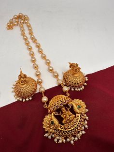 Goddess Lakshmi Peacock Pendent Set with Pearl Mala and Matching Jhumki Simple dainty Pendent Sets for any occasion. It comes with pearl mala but can be used with any gold chain or beads too, Pendent Length Approx. 2 Inches Pearl Mala Length : Approx. 24 Inches;  Earring Length : Approx. 1.5 Inches; Push back. Ready to ship from Boston, MA Delivery time 3-5 days. If you have any questions please let me know. Thank you!! Diwali Chandbali Jewelry Sets With Latkans, Temple Necklace With Pearl Chain As Diwali Gift, Diwali Temple Jewelry Sets With Latkans, Traditional Festive Jewelry Set With Pearl Pendant, Festive Traditional Jewelry Set With Pearl Pendant, Festival Temple Jewelry Sets With Latkans, Bollywood Style Pearl Chain Jewelry Sets For Diwali, Diwali Temple Jewelry Necklace With Pearl Chain, Diwali Temple Jewelry Sets With Pearl Chain