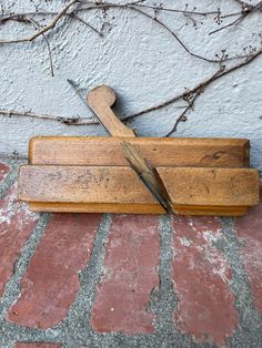 a pair of scissors sitting on top of a wooden cutting board next to a wall