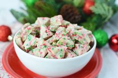 a white bowl filled with christmas sprinkles on top of a red plate