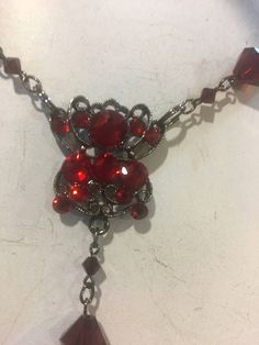 This is a beautiful red long necklace that can be adjusted and used multi ways. Wrap it around your neck for a choker look or adjust it to fit however you wish. Ruby red crystal beads plated in black . Cross has crystals on both sides. Red Metal Choker For Party, Red Ruby Choker Necklace, Red Gothic Cross Necklace, Elegant Red Crystal Pendant Necklace, Red Gothic Necklace For Formal Occasions, Red Adjustable Cross Necklace, Red Choker Necklaces For Formal Occasions, Adjustable Red Cross Necklace, Red Choker Necklace For Formal Occasions