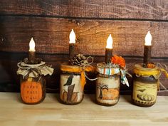 three jars with candles in them sitting on a table