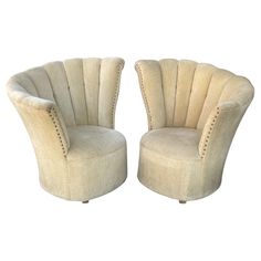 a pair of beige chairs sitting next to each other on top of a white floor