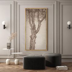 a living room with two black chairs and a large painting on the wall above it