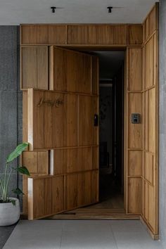 an open wooden door leading into a room with concrete walls and flooring on both sides