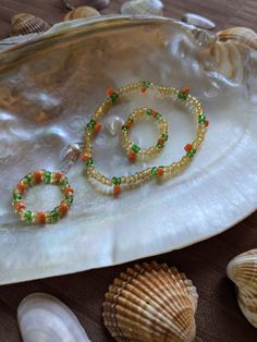 two bracelets sitting on top of a shell next to shells