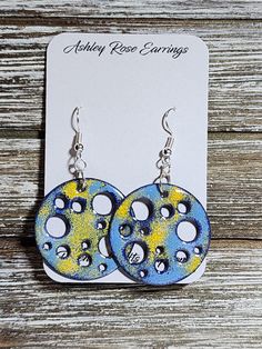 Holey Circles with Blues and Yellow; unique one of kind enameled earrings. All products include exchange of equal or lesser value if in 30 days of purchase if front glass chips away noticeably showing copper.  Send me a picture of the earrings and your contact information. Nickel-free Blue Circular Earrings, Blue Nickel-free Round Earrings, Nickel-free Blue Earrings, Cadmium-free Blue Earrings As Gift, Artsy Round Blue Jewelry, Artsy Blue Enamel Jewelry, Artsy Blue Round Jewelry, Blue Cadmium-free Drop Earrings, Unique Hand Painted Blue Earrings