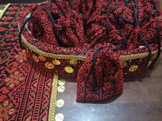 a red and black purse sitting on top of a table next to some gold coins