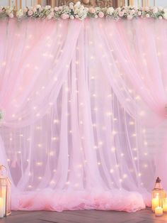 a wedding stage decorated with pink tulle and candles