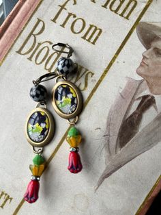 Art Nouveau Girlfriends Glass Cameo Earrings. Colorful cameo of vintage poster art depicting friends at lunch or tea reading the latest fashion magazines. Adorned with colorful glass beads and jewels. Lovely and OOAK! Note: The majority of my earrings can be converted to clip ons - please convo me. Handmade Adjustable Vintage Clip-on Earrings, Retro Earrings With Vintage Charm For Gift, Vintage Earrings With Artistic Design For Gift, Vintage Earrings With Artistic Design As Gift, Vintage Artistic Design Earrings As A Gift, Vintage Multicolor Earrings For Gifts, Retro Dangle Clip-on Earrings For Gift, Vintage Multicolor Earrings As Gift, Vintage Red Hand Painted Jewelry