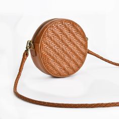 Stay stylish with this trendy Women's Brown Woven Crossbody Round Purse. Made from high-quality genuine leather, this bag features a unique woven design and exquisite stitching details. Its compact size makes it perfect for carrying your essentials, while the softness of the leather adds a touch of luxury.

 	Material: Genuine leather
 	Size: 18cm x 7cm
 	Color: Brown
 	Interior features: Zippered pocket, phone pocket, ID pocket
 	Closure: Zipper
 	Trendy woven design and stitching details Brown Leather Shoulder Bag With Interwoven Design, Brown Leather Bags With Interwoven Design, Chic Brown Shoulder Bag With Interwoven Design, Trendy Braided Leather Shoulder Bag, Trendy Leather Bags With Braided Details, Versatile Woven Leather Shoulder Bag, Trendy Braided Leather Bag, Travel Bags With Interwoven Design, Brown Braided Crossbody Bag