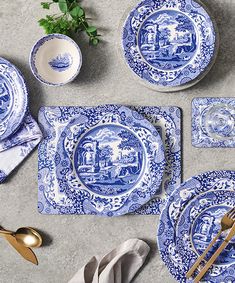 blue and white dinnerware with gold utensils on the side, next to an empty plate