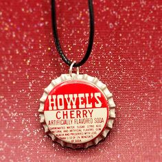 a bottle cap necklace with the words howie's cherry on it