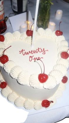 a heart shaped cake with cherries on it and the words twenty one written in red